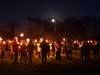 Congregation by moon and torchlight